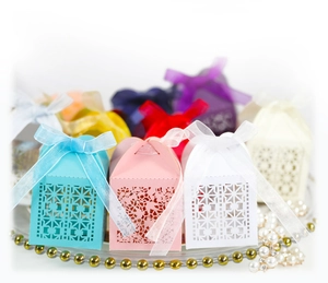 Elegant laser-cut gift boxes in pastel colors with silk bows for wedding candy and chocolate