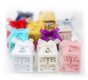 Laser-cut hollow Christmas gift boxes in multiple colors with deer patterns and ribbons