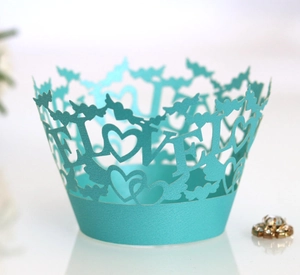 Macro view of Tiffany blue laser-cut cupcake wrapper with LOVE lettering and heart patterns