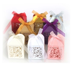 Laser-cut wedding favor boxes with floral hollow patterns and matching silk ribbons