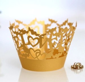 Macro detail of laser-cut gold pearlescent cupcake wrappers with LOVE heart pattern
