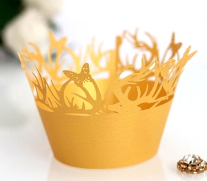 Ginger yellow laser-cut cupcake wrappers with butterfly and antler design on white background