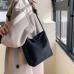 Sac fourre-tout noir minimaliste en faux daim avec texte embossé et détail de nœud