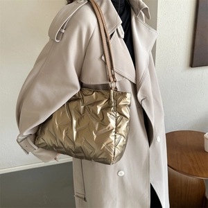 Sac fourre-tout matelassé doré métallisé avec lanières en cuir marron sur modèle
