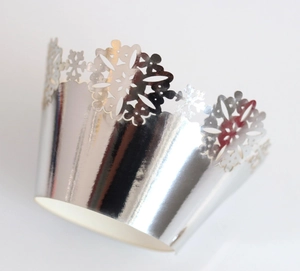 Detail of silver laser-cut snowflake pattern on metallic cupcake wrapper for Christmas