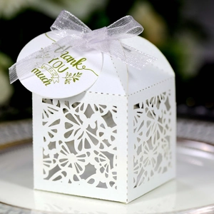 Detail of white laser-cut candy box with butterfly patterns and Thank You tag