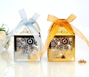 Detail of laser-cut hollow floral gift boxes in gold and silver with elegant satin ribbons