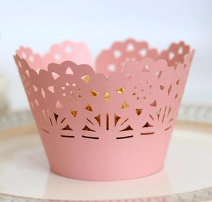Pink laser-cut cupcake wrappers with floral lace pattern for elegant wedding party decor