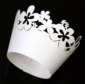 Macro shot of laser-cut white floral lace cupcake wrapper with pearlescent finish