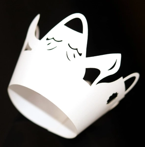Macro shot of a white laser-cut Halloween ghost crown wrapper with a cute cartoon face