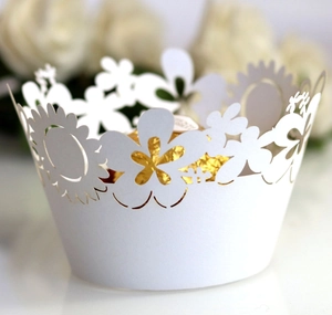 Close-up of laser-cut white cupcake wrappers with sunflower patterns and chocolate interior