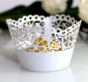 Close-up of laser-cut white lace cake wrappers with elegant heart and floral patterns