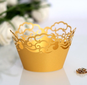 Macro shot of laser-cut golden cupcake liners with elegant hollowed cloud patterns