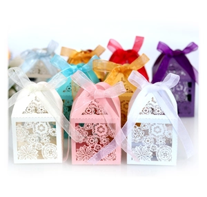 Laser-cut wedding favor boxes with floral patterns and organza ribbons in various colors