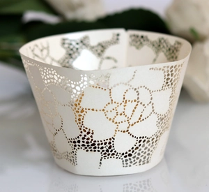 Macro shot of laser-cut rose hollow cupcake wrapper with pearlescent ivory paper finish