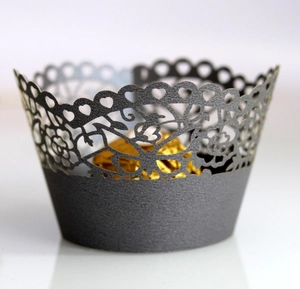 Detail view of laser-cut lace cupcake wrapper with intricate floral and heart patterns