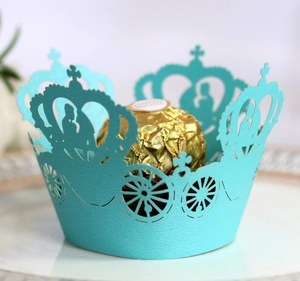 Close-up of laser-cut lake blue pumpkin carriage cake wrapper with gold chocolate
