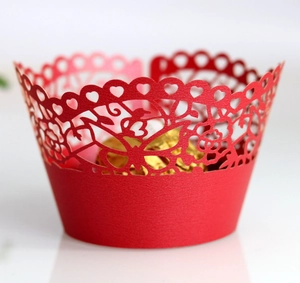 Close-up of red laser-cut cupcake wrapper with floral, heart and butterfly patterns