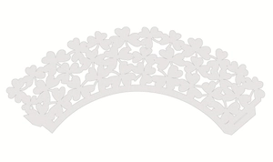 Detail of white laser-cut clover cupcake wrappers showing delicate hollow pattern