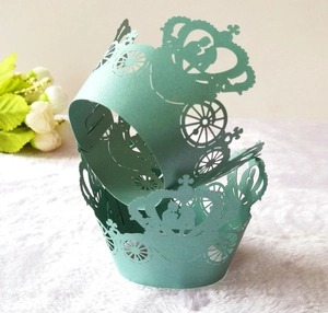 Detail of mint green laser-cut cupcake wrappers with crown and carriage lace patterns