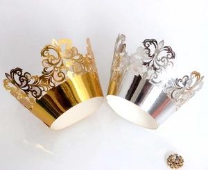 Detail of hollowed crown lace cupcake wrappers in gold and silver finish with rhinestones