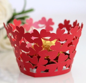 Detail of red hollow laser-cut clover cupcake wrappers showing delicate patterns