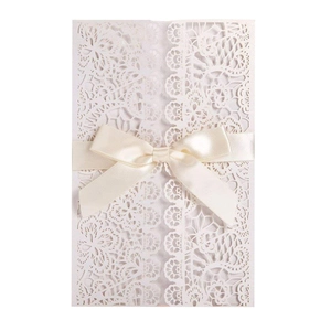 Elegant laser-cut floral wedding invitation with ivory ribbon bow on white background