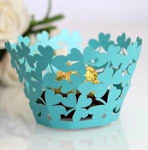Macro shot of sky blue laser-cut cupcake wrapper featuring delicate clover pattern