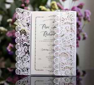 Macro shot of laser-cut floral wedding invitation with detailed hollow lace patterns