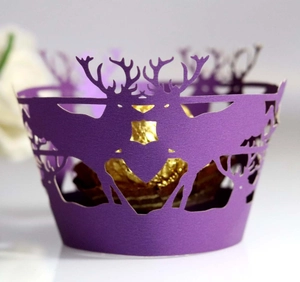 Detail of laser-cut purple cupcake wrapper with reindeer and forest silhouette pattern