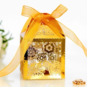 Elegant gold laser-cut floral gift box featuring a glossy finish and orange-gold ribbon bow
