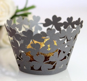 Detail of dark grey four-leaf clover laser-cut cupcake wrappers for wedding decor
