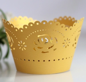 Yellow laser-cut cupcake wrapper with hollow rose pattern and scalloped edges
