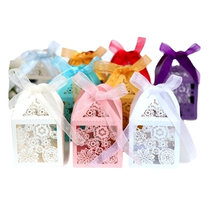 Laser-cut hollow wedding candy boxes in assorted colors with decorative silk ribbon bows