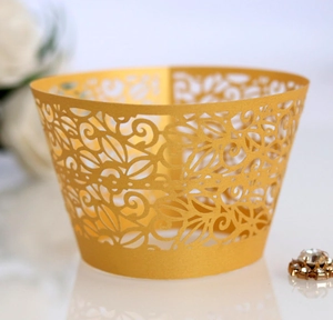 Detailed laser-cut gold lace cupcake wrappers with intricate floral patterns for party decor