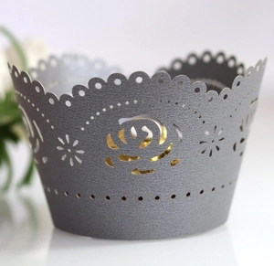 Macro view of grey laser-cut rose cake wrapper with delicate scalloped dot edges