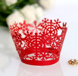 Macro shot of red laser-cut snowflake cupcake wrappers for Christmas dessert table