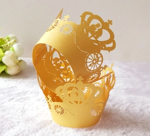 Macro detail of laser-cut golden cupcake wrappers with carriage and crown patterns