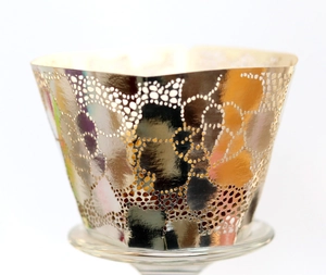 Detailed macro view of laser-cut white rose lace pattern on pearlescent cupcake wrappers