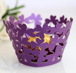 Detail of laser-cut lavender cupcake wrappers with intricate clover patterns and chocolate