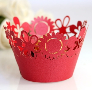 Macro view of detailed sunflower laser cut-out patterns on red cupcake wrappers