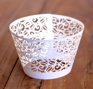 Elegant white laser-cut lace cupcake wrappers for wedding and party dessert tables