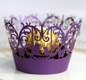 Laser cut deep purple cupcake wrapper with intricate bird and floral pattern