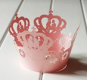 Detailed laser-cut pink cupcake wrapper featuring romantic crown and wedding carriage patterns