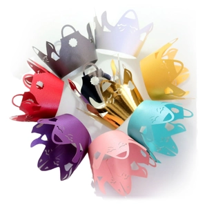 Set of colorful crown-shaped laser cut cupcake wrappers with hollow smiley face designs