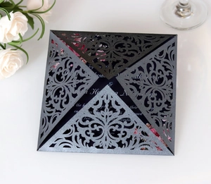 Close-up of laser-cut wedding invitation with pearl shimmer paper and floral insert