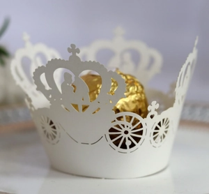 Intricate laser-cut crown and pumpkin carriage white paper cupcake wrappers detail