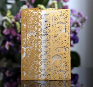 Detail showing the intricate laser-cut golden lace pattern on a premium wedding invitation