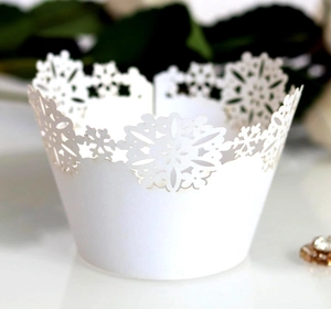 Laser-cut white cupcake wrappers with snowflake and floral patterns for party decoration