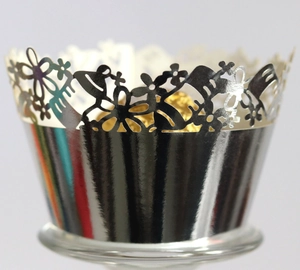 Close-up of laser-cut silver mirror cupcake wrappers with intricate floral patterns